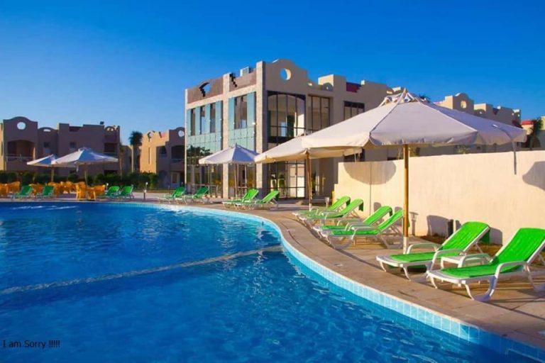 Piscina exterior con tumbonas verdes y sombrillas blancas del Green Leaves Hotel en Egipto