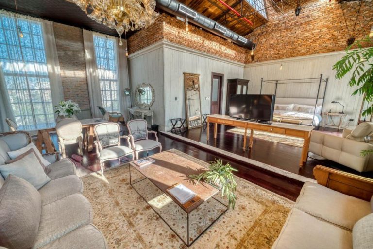 Suite loft de estilo industrial con sala de estar y zona de dormitorio en Factoria Hotel