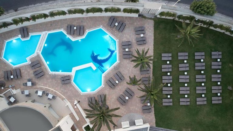 Vista aérea de la piscina exterior con mosaico de delfín del Cactus Hotel Adults Only 21 Plus