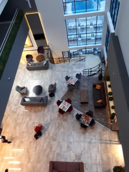 Amplio lobby moderno con zona de descanso y mesas del Ramira City Hotel Adult Only visto desde altura