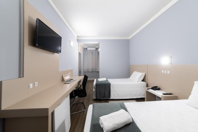 Habitación twin con dos camas, escritorio y televisión del Rede Andrade Cecomtur