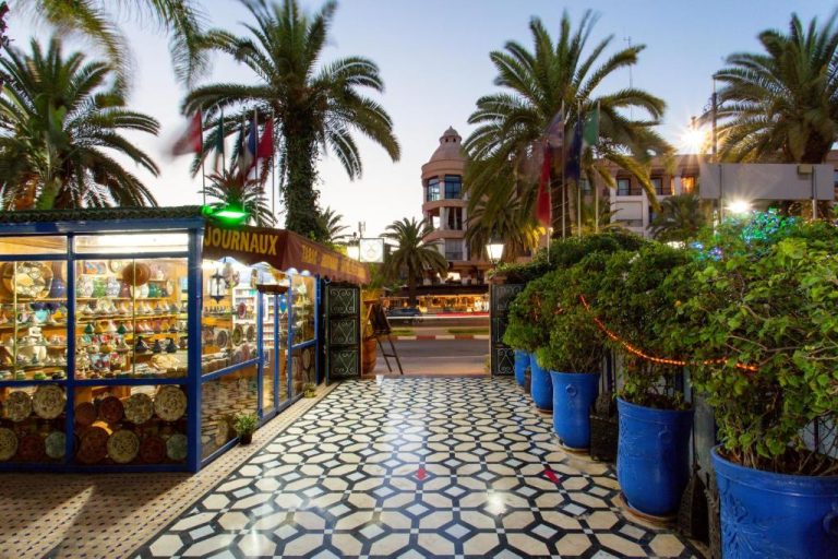 Entrada principal del Hotel Akabar con tienda de artesanía marroquí, palmeras y suelo de mosaico tradicional