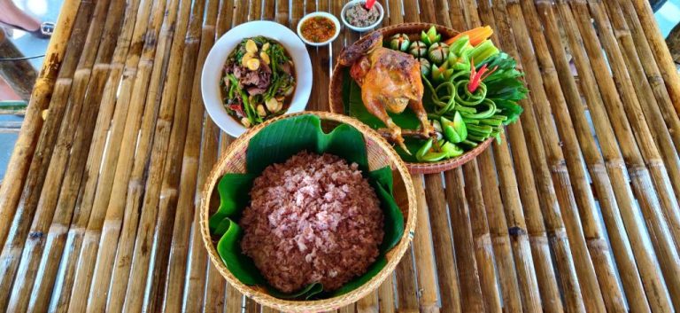 Platos típicos locales con arroz rojo, pollo asado y verduras frescas servidos en el Glorious Hotel