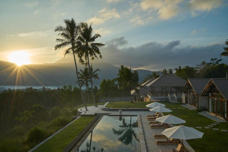 Piscina infinita con tumbonas y vistas a las montañas al atardecer en el hotel Palmterrace