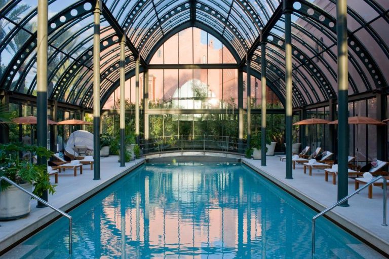 Piscina interior cubierta con techo acristalado y tumbonas del Royal Mansour Marrakech