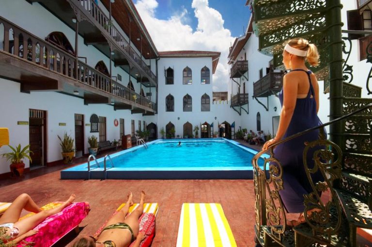 Piscina exterior en el patio interior del Tembo House Hotel con tumbonas y arquitectura colonial de Zanzíbar