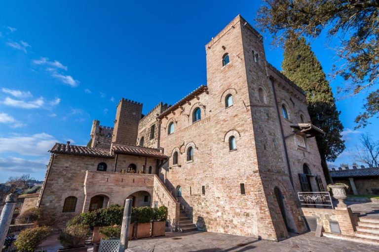 Fachada medieval del Castello di Monterone en Perugia con torre de piedra y escalinata exterior