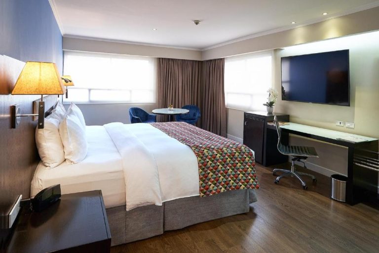 Habitación superior con cama doble, escritorio de trabajo y TV en el Hotel Oro Verde Guayaquil
