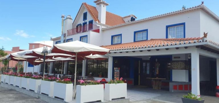 Terraza exterior con sombrillas y jardín de flores del Hotel O Colmo en Portugal