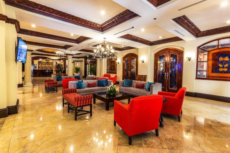 Elegante lobby del Clarion Hotel Real Tegucigalpa con sillones rojos y sofás grises en lujoso salón