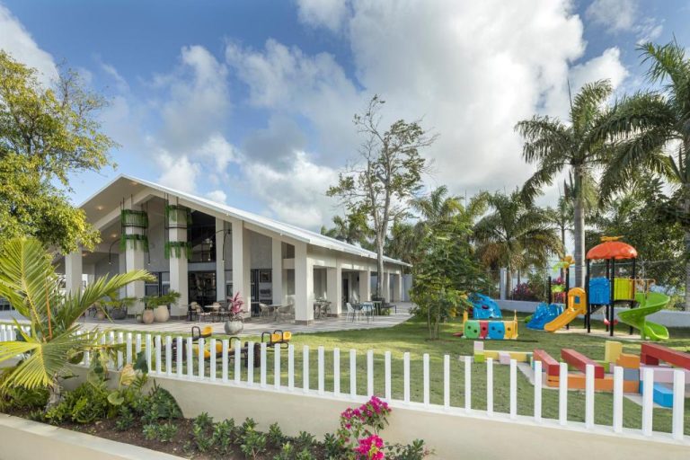 Zona de juegos infantil y jardines exteriores del Hotel Yonu con palmeras tropicales