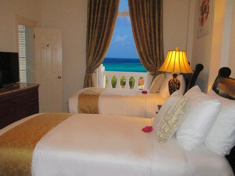 Habitación doble con camas queen y vista al mar turquesa en Ocean West Boutique Hotel