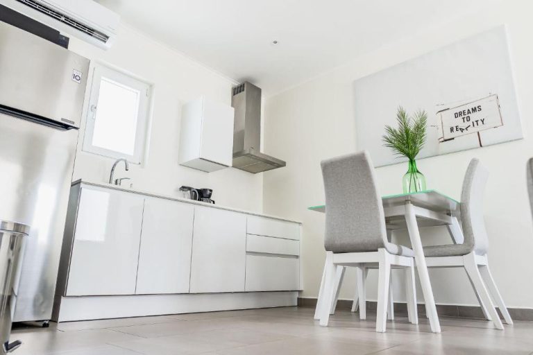 Cocina y comedor modernos con electrodomésticos en acero inoxidable en The Palm Leaf Apartments