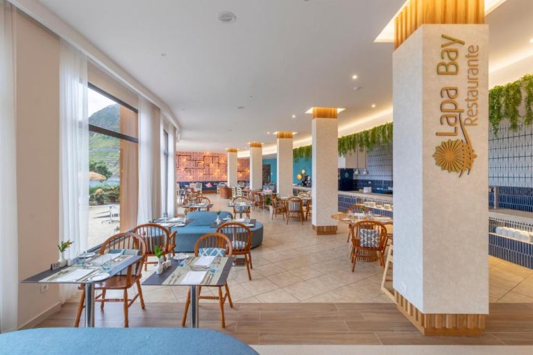 Restaurante Lapa Bay del hotel Aqua Natura Bay con mesas y vistas al mar en Madeira