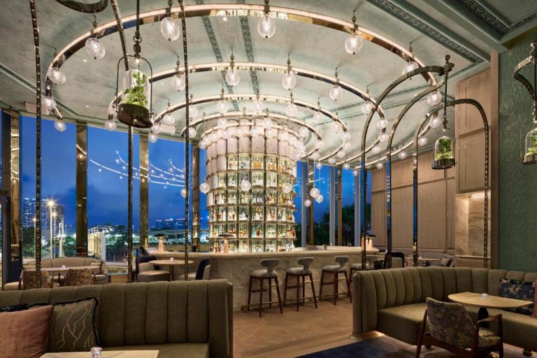Elegante bar con torre de botellas iluminada y arcos de cristal en el Four Seasons Hotel Hong Kong