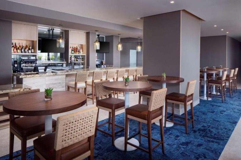 Bar y área de restaurante con mesas altas y taburetes del Hyatt Place Aruba Airport