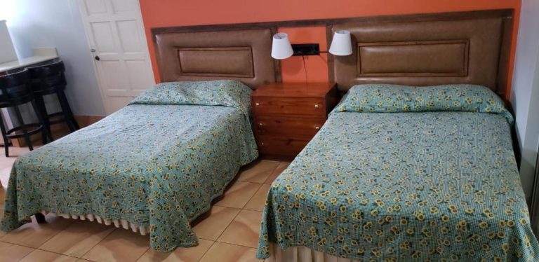Habitación doble con dos camas y colchas de girasoles en Negril Beach Club Condos Jamaica