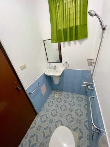 Baño completo con ducha teléfono, lavabo y azulejos azules en Chislyk Inn