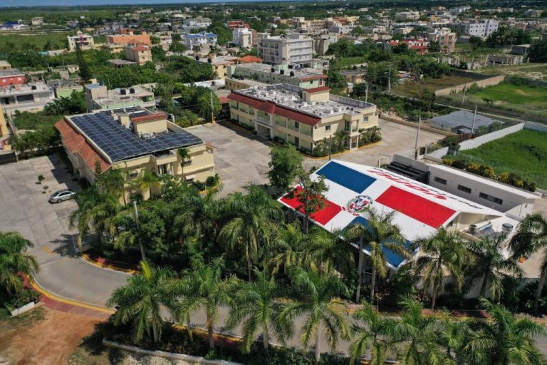Vista aérea del Hotel Yonu con paneles solares, palmeras y techo con bandera dominicana pintada