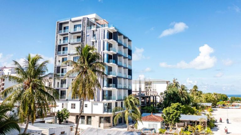 Fachada exterior del Triton Prestige Seaview and Spa, edificio moderno con balcones y palmeras frente al mar