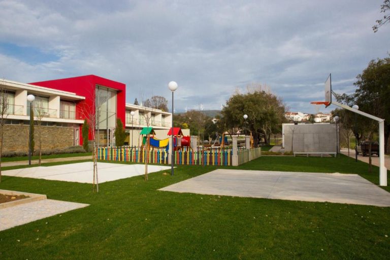 Zona infantil con parque de juegos y cancha de baloncesto en los jardines del Hotel Santa Margarida