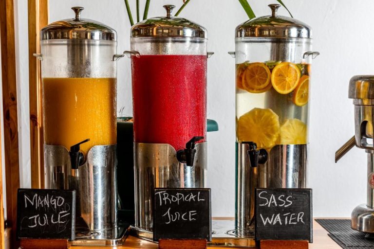 Dispensadores de zumo de mango, tropical y agua con frutas en el buffet del PrideInn Flamingo Beach Resort