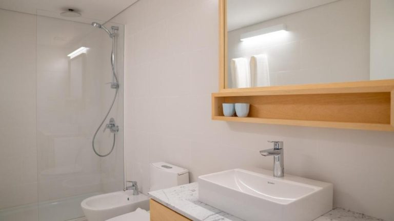 Baño moderno con ducha acristalada, bidé y lavabo sobre encimera de mármol en Casagrande Hotel & Beach Club