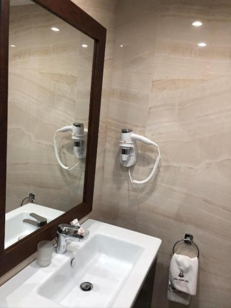 Baño moderno con lavabo, espejo y secador de pelo del Hotel familiar Anna-Cristina