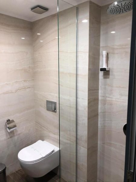 Baño moderno con ducha de lluvia y sanitario suspendido en Hotel Anna-Kristina