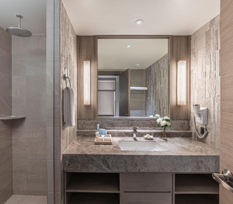 Baño de lujo con encimera de mármol, ducha de lluvia y amenities en Henann Park Resort