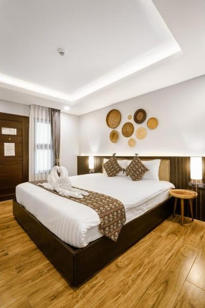 Habitación doble con cama king size y decoración artesanal en Paraiso Hotel Chiangmai