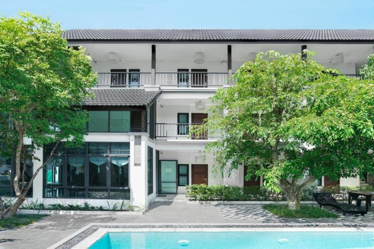 Piscina exterior con jardín y fachada principal del Paraiso Hotel Chiangmai en Tailandia