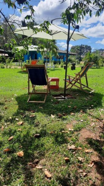 Tumbonas de madera con sombrilla en el jardín del Hotel de Campo Villa de Ada
