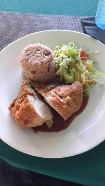 Plato de pollo frito con arroz y ensalada fresca servido en Beach Studio 20