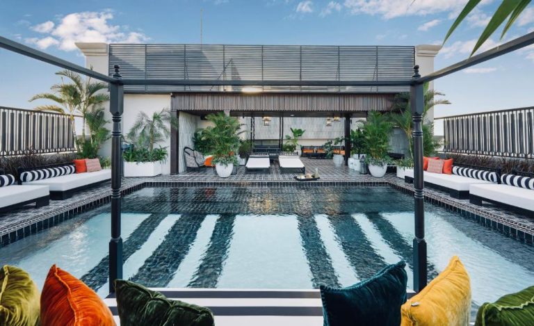 Piscina en terraza rooftop con tumbonas y zona lounge del Sanouva Da Nang Hotel en Vietnam