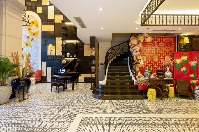 Lujoso lobby del Sanouva Da Nang Hotel con escalera de mármol, piano de cola y decoración vietnamita tradicional