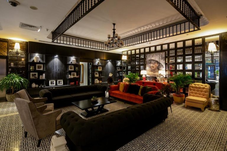 Elegante lobby con sofás de terciopelo negro y rojo en el Sanouva Da Nang Hotel de Vietnam