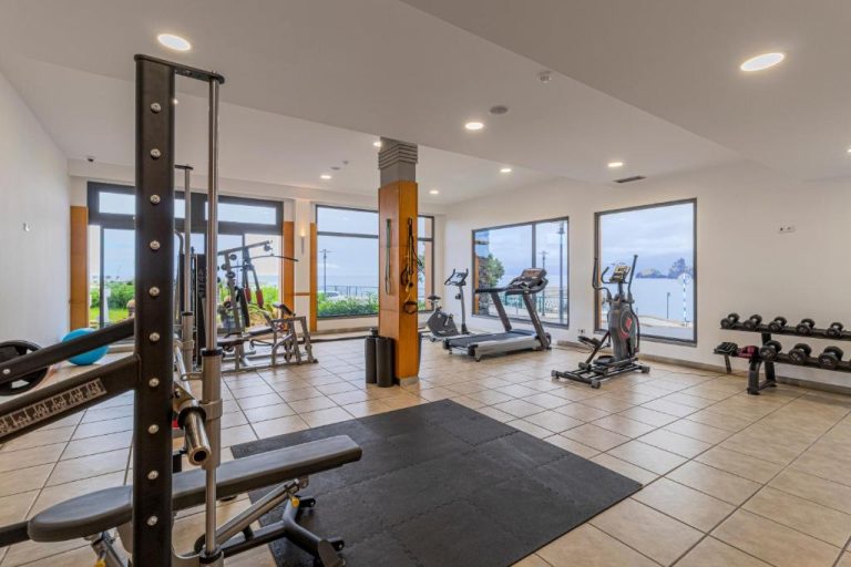 Gimnasio equipado con vistas al mar del Hotel Aqua Natura Madeira, con cintas y mancuernas