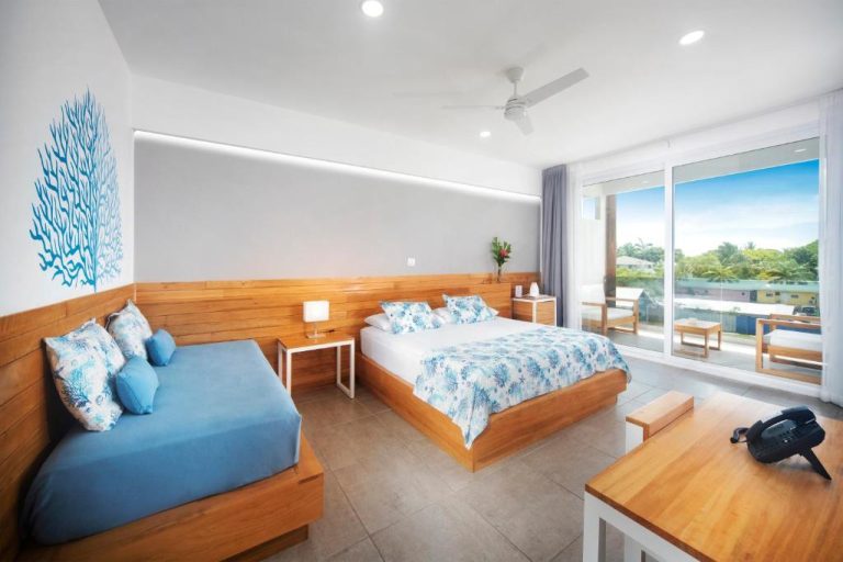 Habitación doble con decoración marina, cama de madera y terraza exterior en Naboo Resort & Dive Center Adults Only