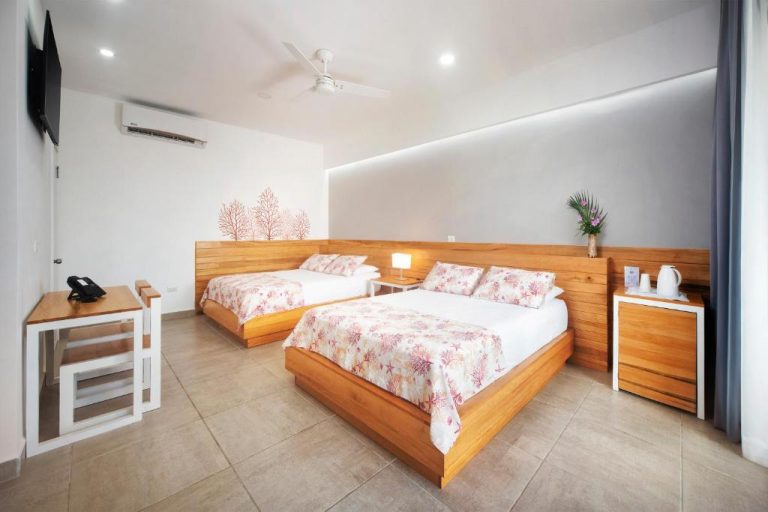Habitación doble con camas de madera y decoración tropical en Naboo Resort & Dive Center Adults Only