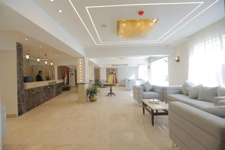 Elegante lobby con recepción y sofás grises del Jewel Sharm El Sheikh Hotel en Egipto