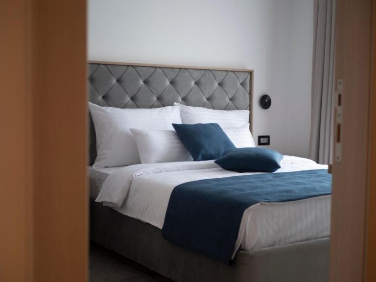 Habitación de lujo con cama doble y cabecero tapizado en gris del Hotel Idila Budva