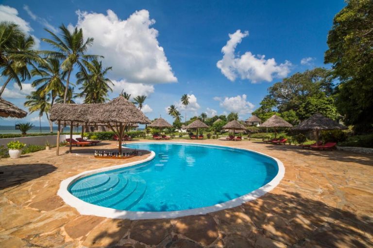 Piscina exterior con hamacas y palapas del Antonio Beach Hotel & Spa en África Oriental