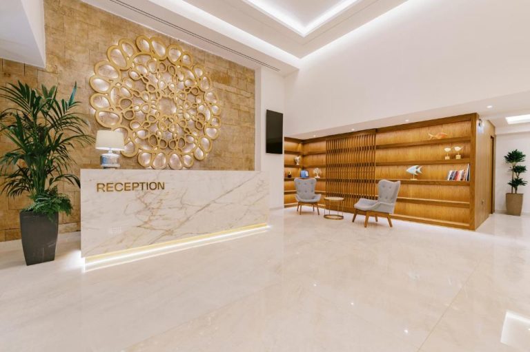 Recepción de mármol con decoración dorada y zona de espera elegante en el Acandia Hotel