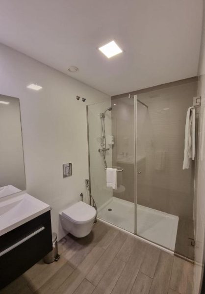 Baño moderno con ducha de cristal y sanitarios en suspensión del Casa do Adro Hotel de Charme