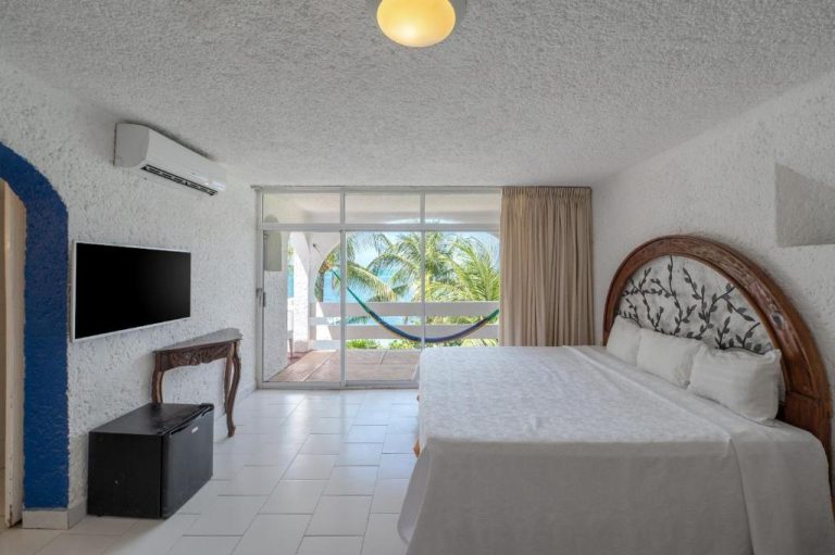 Habitación doble con cama king, televisión y terraza con hamaca y vista al mar en Hotel Maya Caribe Faranda Cancún