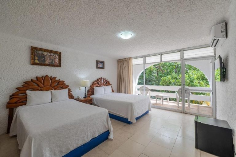 Habitación doble con camas matrimoniales y balcón con vista al jardín en Hotel Maya Caribe Faranda Cancún