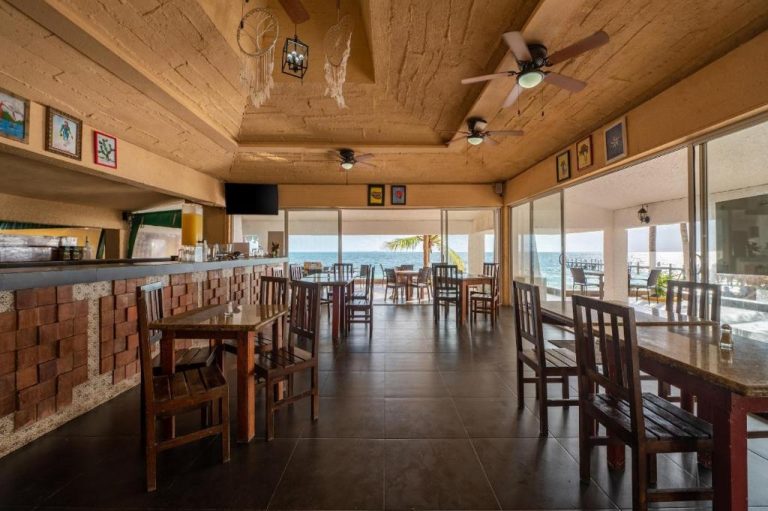 Restaurante interior con vistas al mar del Hotel Maya Caribe Faranda Cancún, con mesas de madera y bar