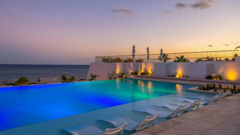 Piscina infinita iluminada al atardecer con vistas al mar en el hotel Royal Azur Thalassa