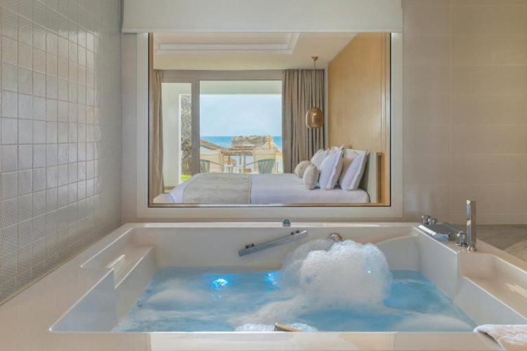 Jacuzzi con burbujeo y vistas al mar desde habitación de lujo en Royal Azur Thalassa